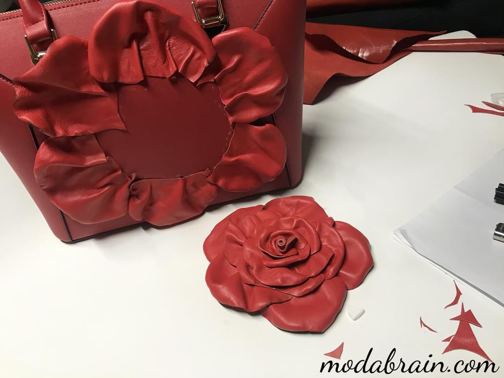 Eine Tasche mit einer großen roten Rose dekorieren
